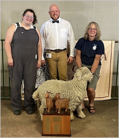 From the left, Jaycee, Judge Eric Stewart and Rhonda with Champion Goat Pom Pom, from Rimini Stilly River Ranch. Photo: Sharon Chestnutt.
